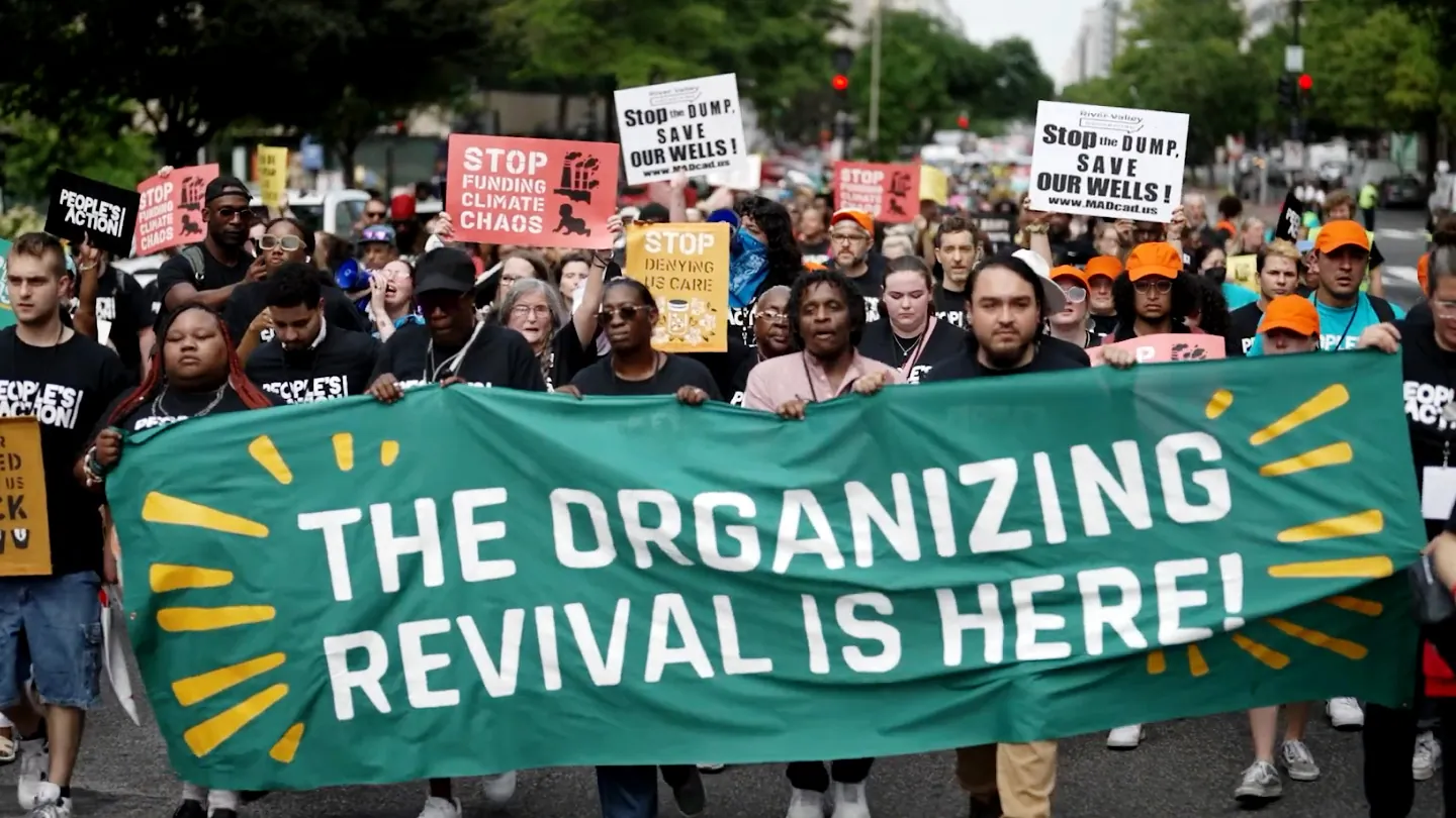 photo of activists marching while carrying a banner that reads "The Organizing Revival is here!"